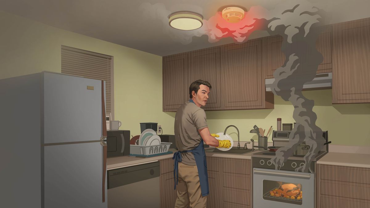 A man washing dishes is surprised by his smoke detector alarm. He turns to look at the smoke rising from his oven.