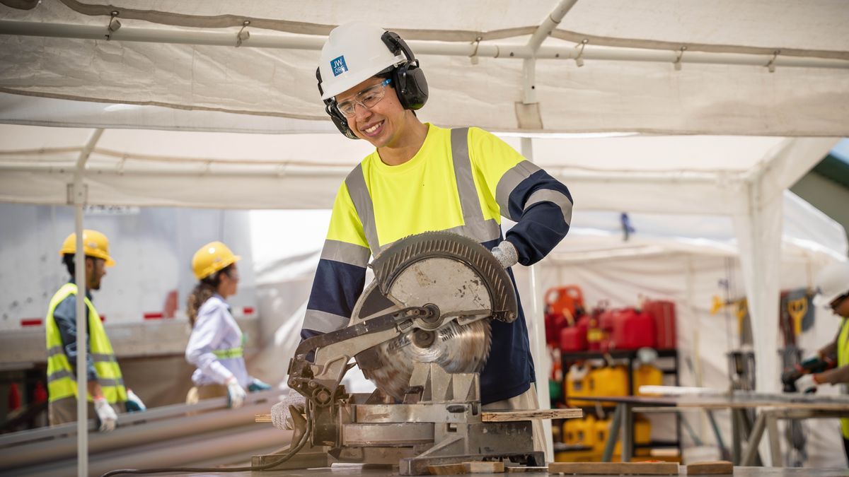 A young brother operates a power saw on a theocratic construction project.